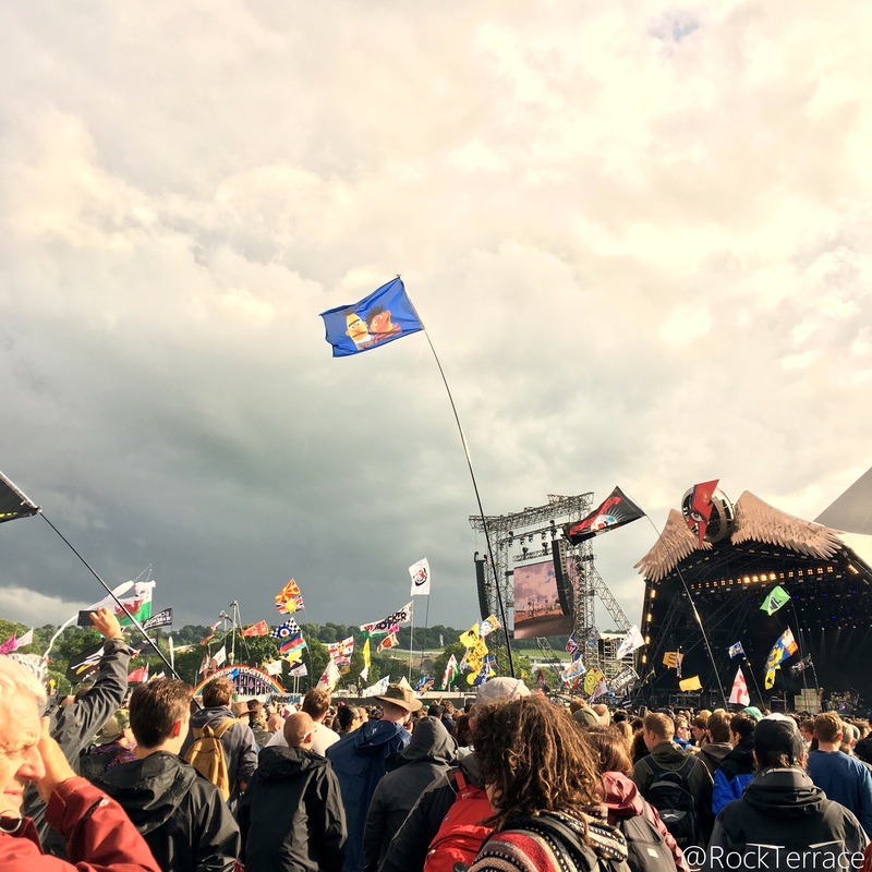 A crowd watching a band on the Pyramid stage at Glastonbury festival
